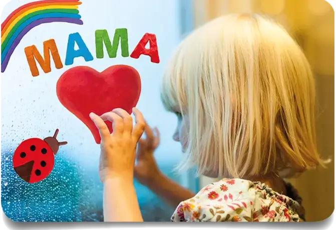 Kind gestaltet ein Herz, einen Regenbogen und einen Marienkäfer aus Fensterknete